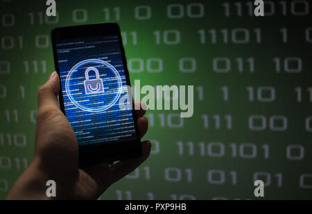 protected in stream of data flow. padlock icon symbolize security and Green binary code computer data in the background. hand holding mobile phone. Stock Photo