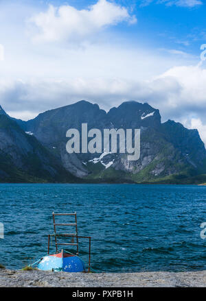 litlle boat at the coast with impressive moutnains in the background- Reine, Lofoten islands, Norway Stock Photo