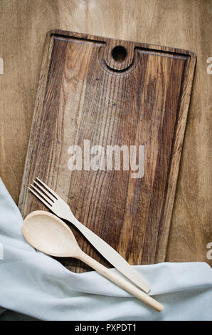 Kitchen Background: Rustic Cutlery with Kitchen Towel or Napkin on Wooden Board Over the Rustic Wooden Table. View From Above With Copy Space Stock Photo