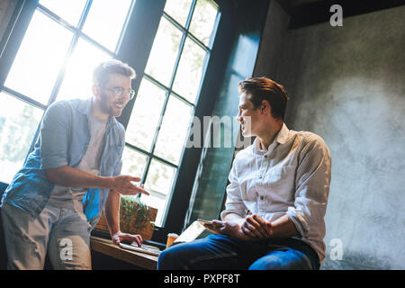 Creatives Having Informal Meeting at a table In Design Studio. Shot of business professionals having a meeting in office. Stock Photo