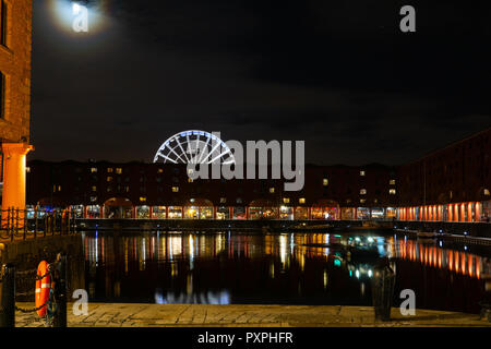 The rising Moon over Albert Dock, Liverpool, Ferris Wheel in background. Image taken in October 2018. Stock Photo