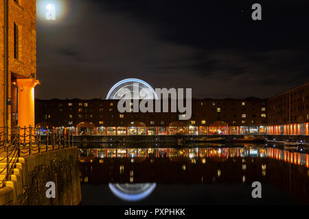 The rising Moon over Albert Dock, Liverpool, Ferris Wheel in background. Image taken in October 2018. Stock Photo