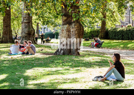 London England,UK,Green Park,Ritz Corner,Royal Parks,lawn,outdoors,green space,sitting on grass,woman female women,boy boys,male kid kids child childr Stock Photo
