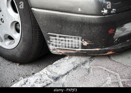 Damaged front car bumper with scratches, close-up photo