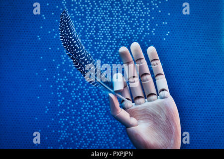 Articulated wooden hand delicately holding a bird feather on a mottled blue background Stock Photo