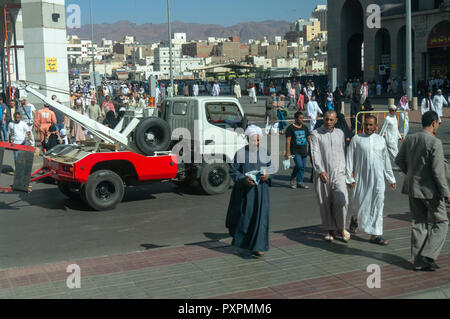 MEDINA, SAUDI ARABIA-CIRCA 2014: Street view of Muslims going to Nabawi mosque for afternoon prayer in Al Madinah, Saudi Arabia. Stock Photo