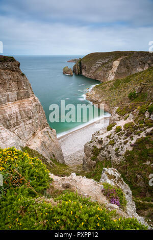 Spectacular cliffs in Cap Frehel, Pointe du Jas, small beach and island Amas du Cap on a cloudy day in summer (Brittany, France) Stock Photo