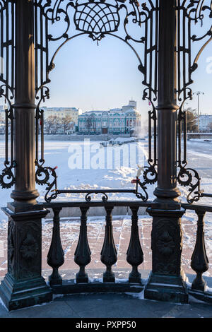 Close-up frame of wrought iron gazebo on waterfront in center of Yekaterinburg with overlooking residences of President and Governor in winter day. Stock Photo