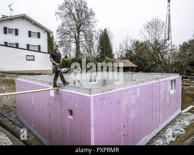 Prefabricated house, workers in setting up the basement walls Stock Photo