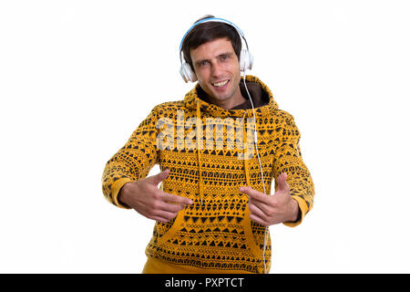 Studio shot of young happy man smiling while listening to music  Stock Photo