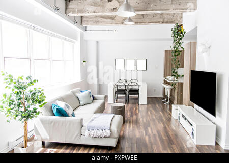 Apartment with big window sofa, table tv and concreate ceiling Stock Photo