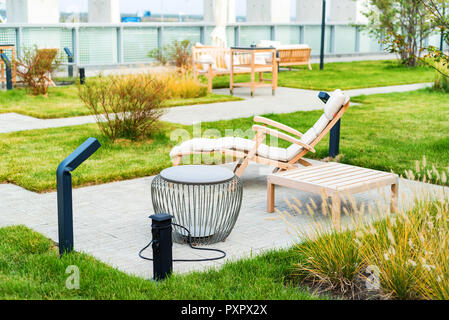 Modern rooftop patio with wooden armchair during the day Stock Photo