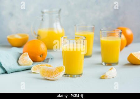 Glasses of freshly squeezed orange juice and orange slices Stock Photo