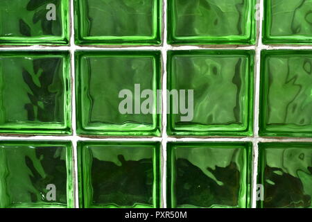 Green glass bricks background. Green glass texture with white lines. Sun light, outdoors. Stock Photo