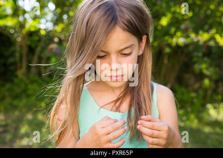 Portrait of serious little girl in the garden Stock Photo