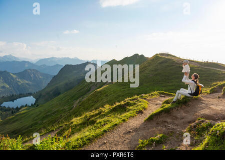 Germany, Bavaria, Oberstdorf, mother and little daughter on a hike in the mountains having a break Stock Photo