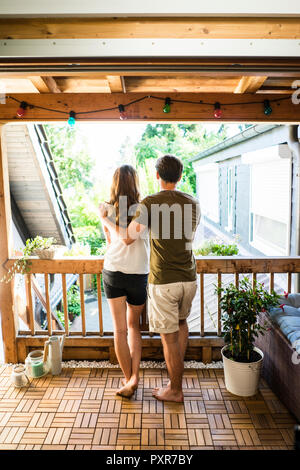 Rear view of couple standing on balcony Stock Photo