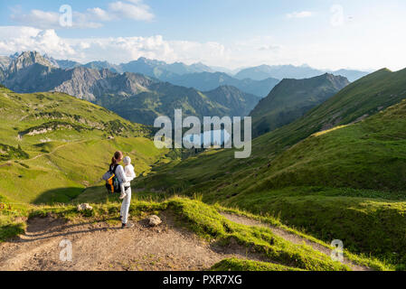 Germany, Bavaria, Oberstdorf, mother and little daughter on a hike in the mountains looking at view Stock Photo