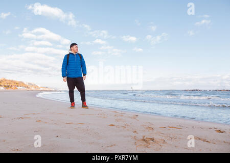 Italy, Molise, Termoli, young man standing at the beach, looking at distance Stock Photo