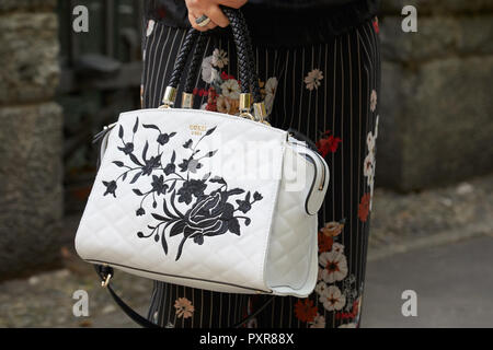 MILAN ITALY SEPTEMBER 22 2018 Woman with white leather Guess bag with floral design before Simonetta Ravizza fashion show Milan Fashion Week str Stock Photo Alamy