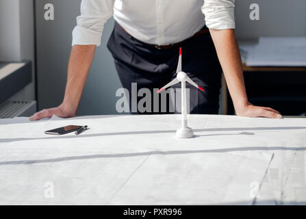 Engineer working in his office with model of a wing´d wheel on his desk Stock Photo