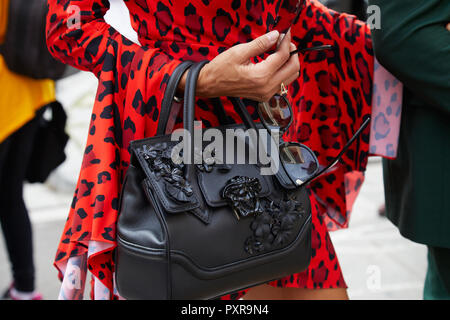 MILAN, ITALY - SEPTEMBER 22, 2018: Woman with black leather Versace bag and  red leopard skin Versace bag before Philosophy fashion show, Milan Fashion  Stock Photo - Alamy