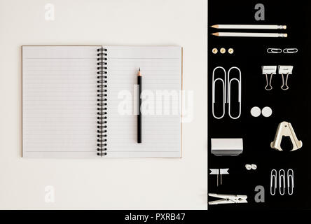 White office utensils on black background and notepad and pencil on whilte background Stock Photo