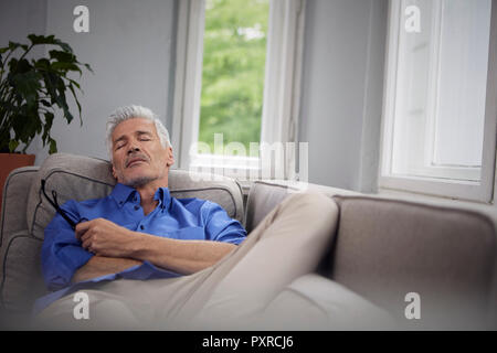 Portrait of mature man relaxing on couch at home Stock Photo