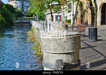 Stone granite  embankment of a small no name Italian city concept. Sunny summer June evening shot. Photo soft focus technique is used to create the at Stock Photo