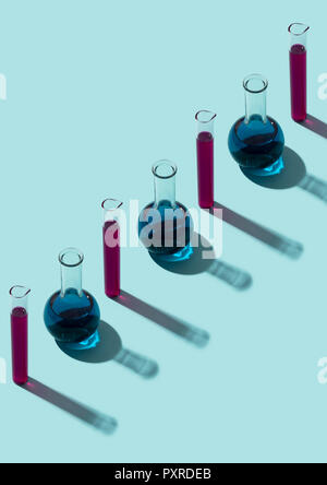 Row of test tubes with liquid, cyan background Stock Photo