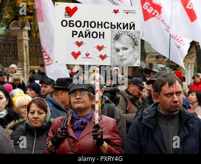 Kiev, Ukraine. 24th Oct 2018. An Ukrainian seen holding a placard with a picture of Ukrainian opposition leader Yulia Tymoshenko, during a protest demanding to cancel the the Cabinet of Ministers decision to raise the gas price by 23.5%, in front of the President Administration in Kiev, Ukraine, on 24 October 2018. On October 19 Ukrainian government decided to raise gas prices for domestic customers in accordance with an International Monetary Fund demand to avoid possible default and in a move to secure fresh loans. Credit: SOPA Images Limited/Alamy Live News Stock Photo