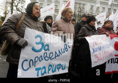 Kiev, Ukraine. 24th Oct 2018. Old women seen holding a placard reading 'For fair tarifs' during a protest demanding to cancel the the Cabinet of Ministers decision to raise the gas price by 23.5%, in front of the President Administration in Kiev. On October 19 Ukrainian government decided to raise gas prices for domestic customers in accordance with an International Monetary Fund demand to avoid possible default and in a move to secure fresh loans. Credit: SOPA Images Limited/Alamy Live News Stock Photo