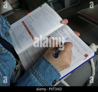 Moscow, Russia, 06.04.2018, studying in the train, hands showcase, Russian/Turkish language study book Stock Photo
