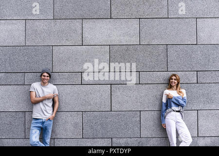 Cheerful couple at the street, show a big sale, or nice offer. Advertise concept. People, travel and tourism - on city street and couple show with the Stock Photo