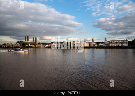 A Thames clipper commuter ferry passing the Greenwich riverfront buildings and Old Royal Naval College in the afternoon sun Stock Photo