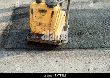 Closeup of a compactor on a new freshly laid asphalt. Stock Photo