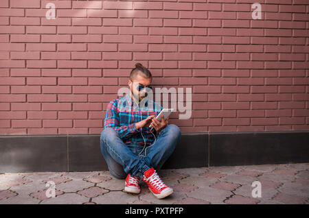 Handsome hipster guy working on digital tablet. Stock Photo