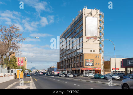 GOODWOOD, SOUTH AFRICA, AUGUST 14, 2018: A street scene, with businesses, vehicles and people, in Goodwood in the Western Cape Province. Lions Head is Stock Photo