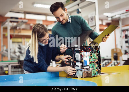 Young attractive students of mechatronics working on project Stock Photo