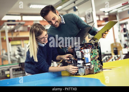 Young attractive students of mechatronics working on project Stock Photo