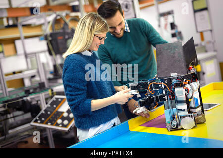 Young attractive students of mechatronics working on project Stock Photo