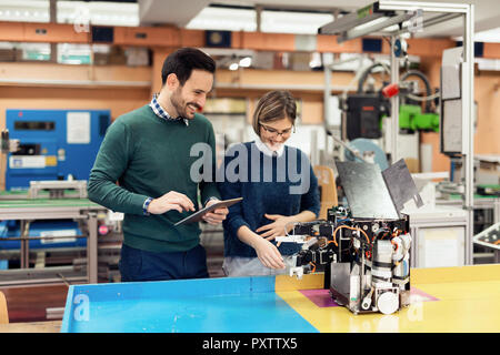 Young attractive students of mechatronics working on project Stock Photo