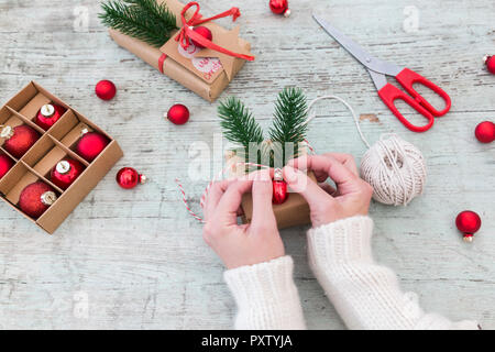 Woman's hands placing decoration on Christmas gift Stock Photo