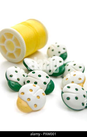 Green and Yellow Coccinelle Sewing Buttons with Yellow Thread Stock Photo