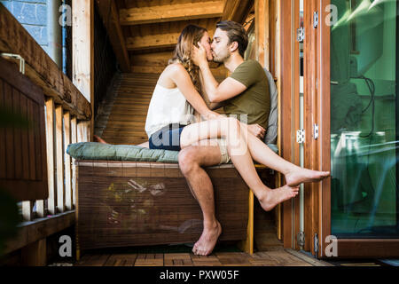Affectionate couple kissing on balcony Stock Photo