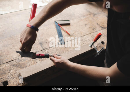 Close-up of carpenter working on piece of wood in workshop Stock Photo