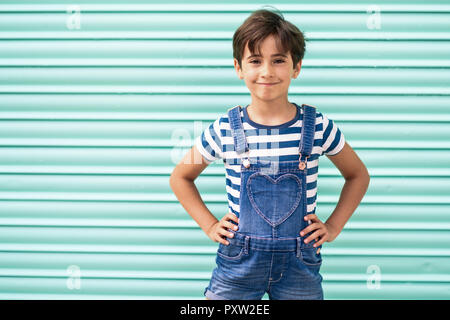 Portrait of smiling little girl wearing dungarees Stock Photo