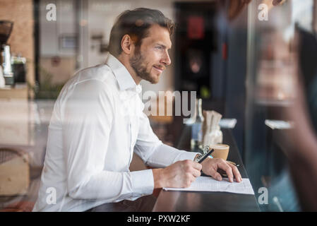 Businessman in a cafe taking notes Stock Photo