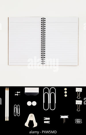 White office utensils on black background and notepad on whilte background Stock Photo