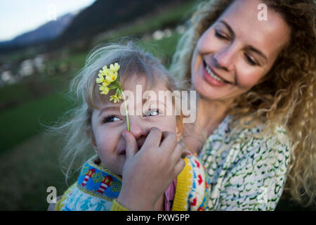 Happy mother and daughter with flowers on a meadow Stock Photo